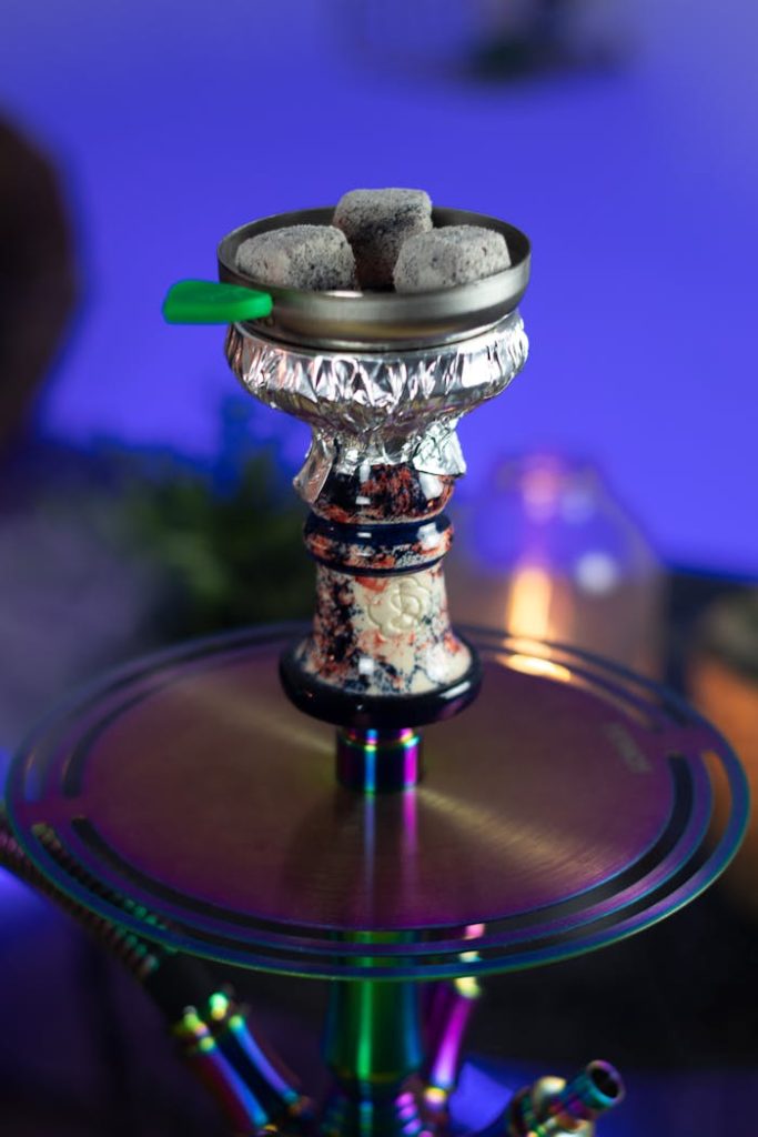 Vibrant close-up view of a hookah setup with glowing charcoals creating a mystical ambiance.